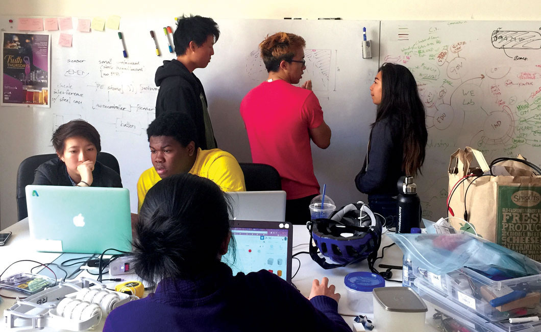 Students looking at board and computers.