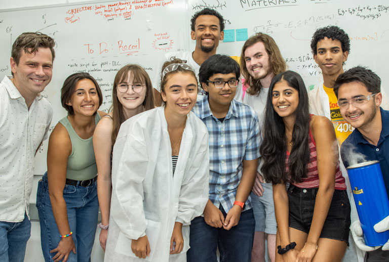 Students pose in front of white board