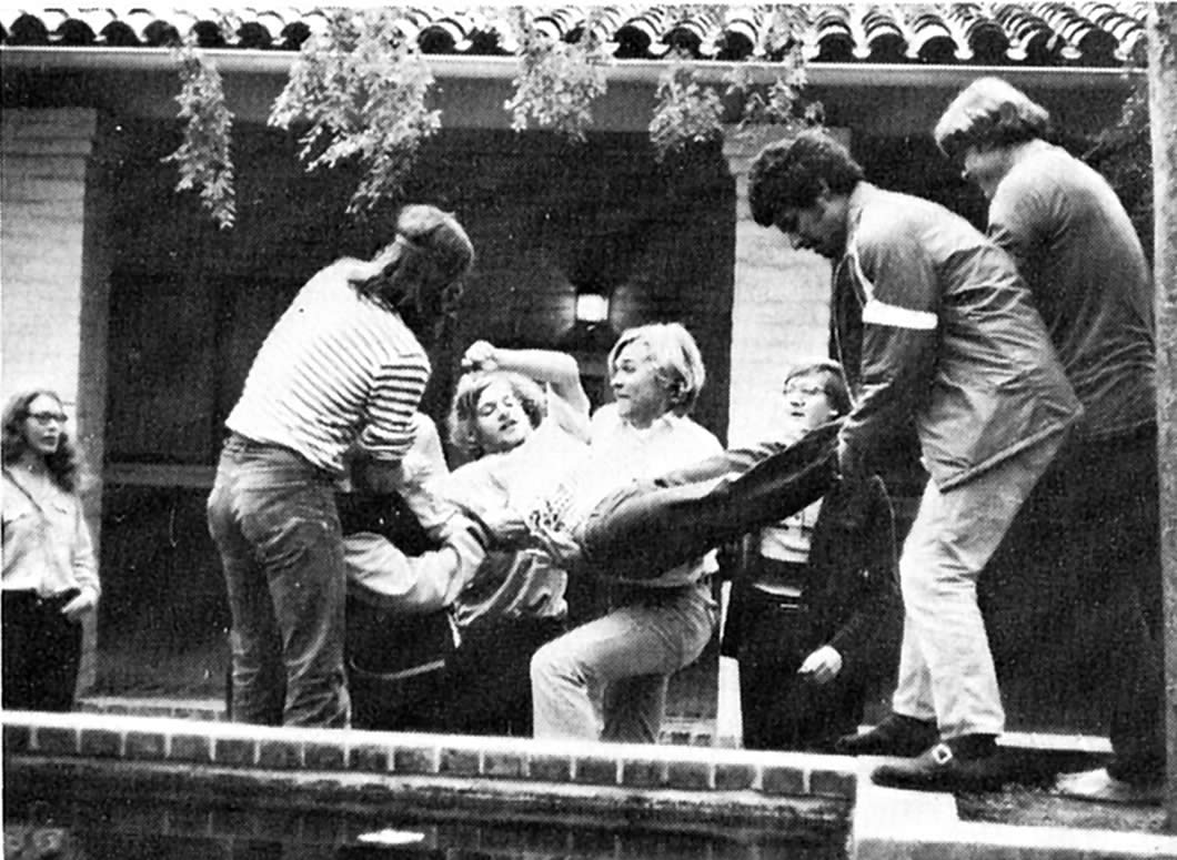  Beverly Orth ’74, left, observes classmates tossing Dan Kalman ’74 into the Seal Pond, May 1973. Her future husband, Tony Noe ’74, is fourth from the right.