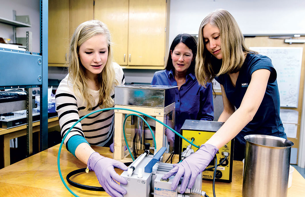 Students work in the lab of physics department Chair Theresa Lynn.