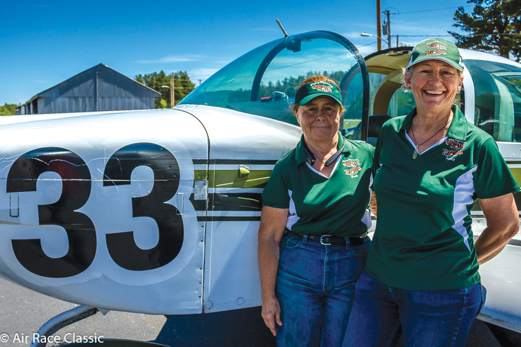 Barbara Filkins and Nancy Smith in front of their airplane.
