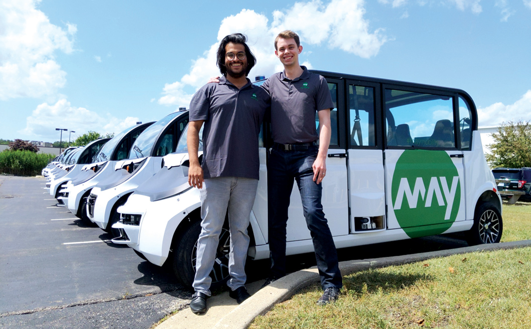 Aman Fatehpuria and Sean Messenger in front of May Mobility self-driving vehicles.