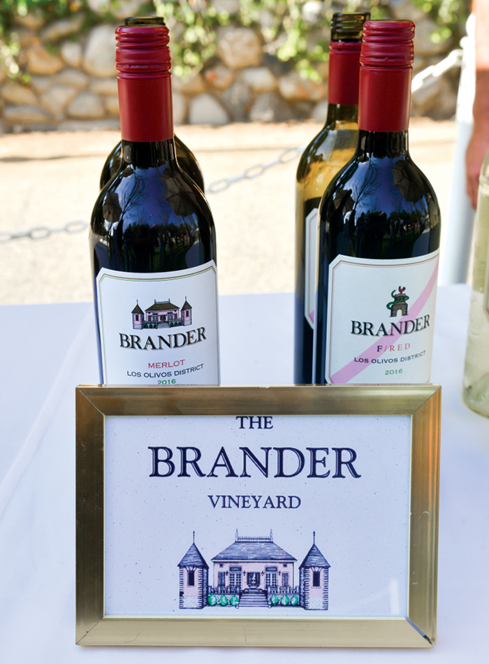 Brander wine bottles on table fronted by Brander Vineyard sign.