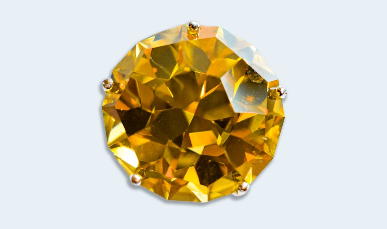 Multi-faceted amber colored gemstone.