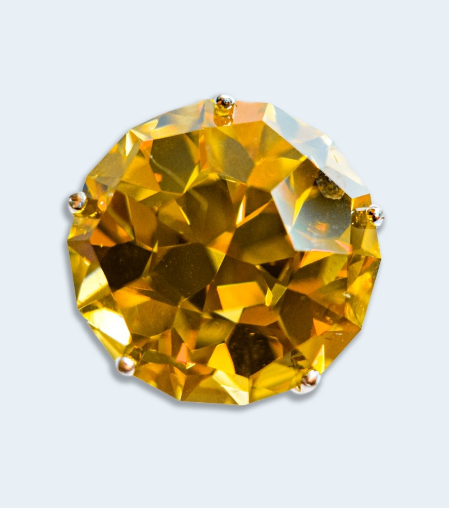 Multi-faceted amber colored gemstone.