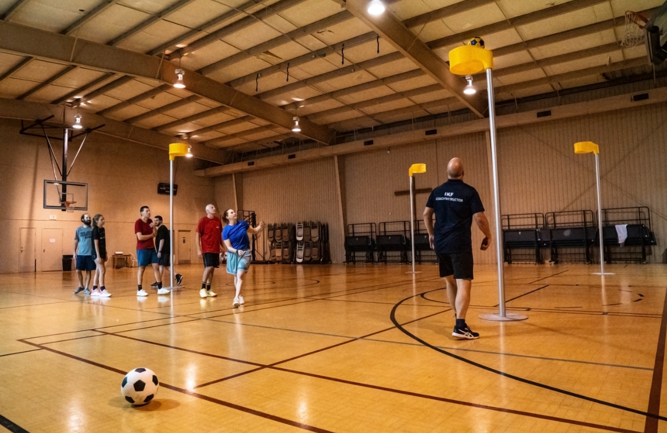 hall set up for korf ball with players practising.